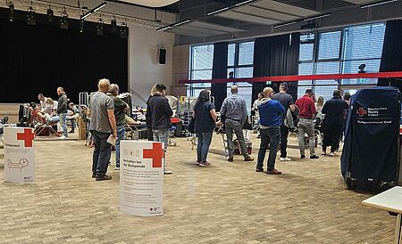 Menschen stehen in einer Schlange und warten auf ihre Blutspende.